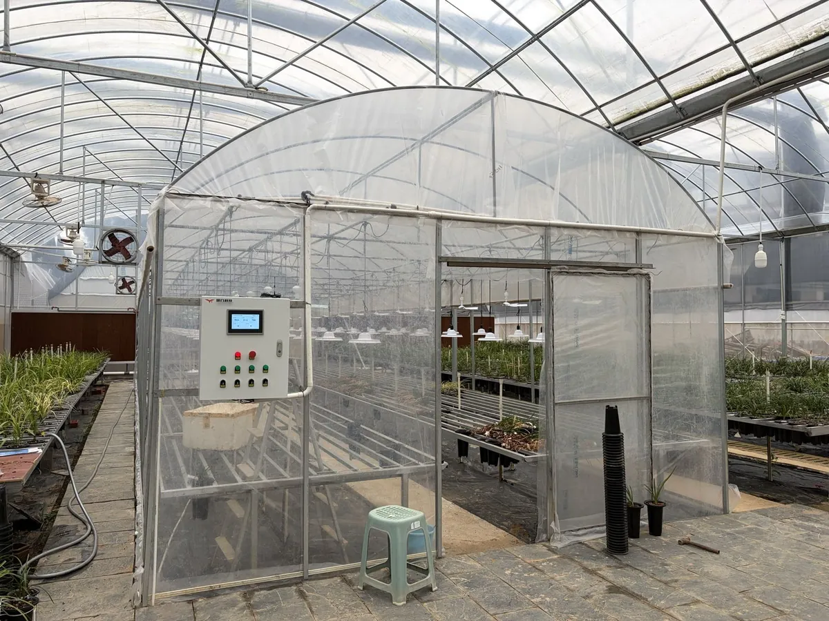 Orchid growing house with a YenGear control cabinet beside the ventilation fans