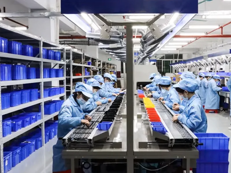 Workers inspecting circuit boards on an electronics assembly line
