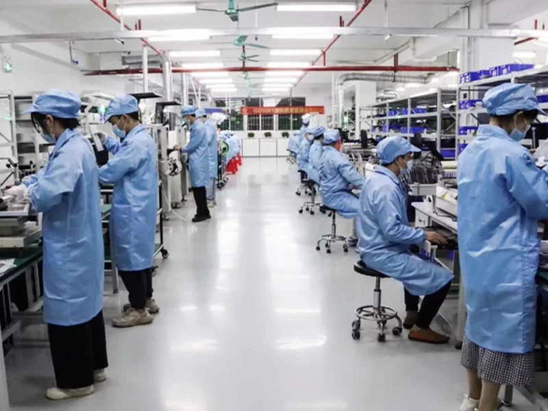 Workers assembling electronic equipment on a production line